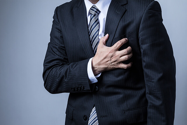 胸部に手を当て痛がっている男性