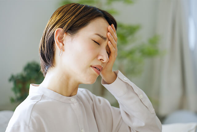 額に手を当てている体調不良の女性